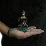 Mitt sitzender Buddha mit Hand hoch