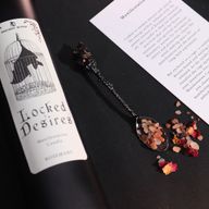 Nahaufnahme des Kerzenetiketts Locked Desires mit einer Fledermaus in einem Käfig