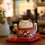 Keramik-Winkekatze mit beweglicher Hand – Rosa auf Kissen (Batterie nicht enthalten)