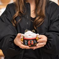 Keramik-Spardose Glückskatze (Maneki-neko) – Schwarz auf Kissen
